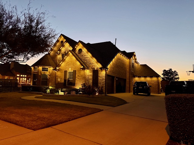 Premium home with permanent holiday lighting at dusk